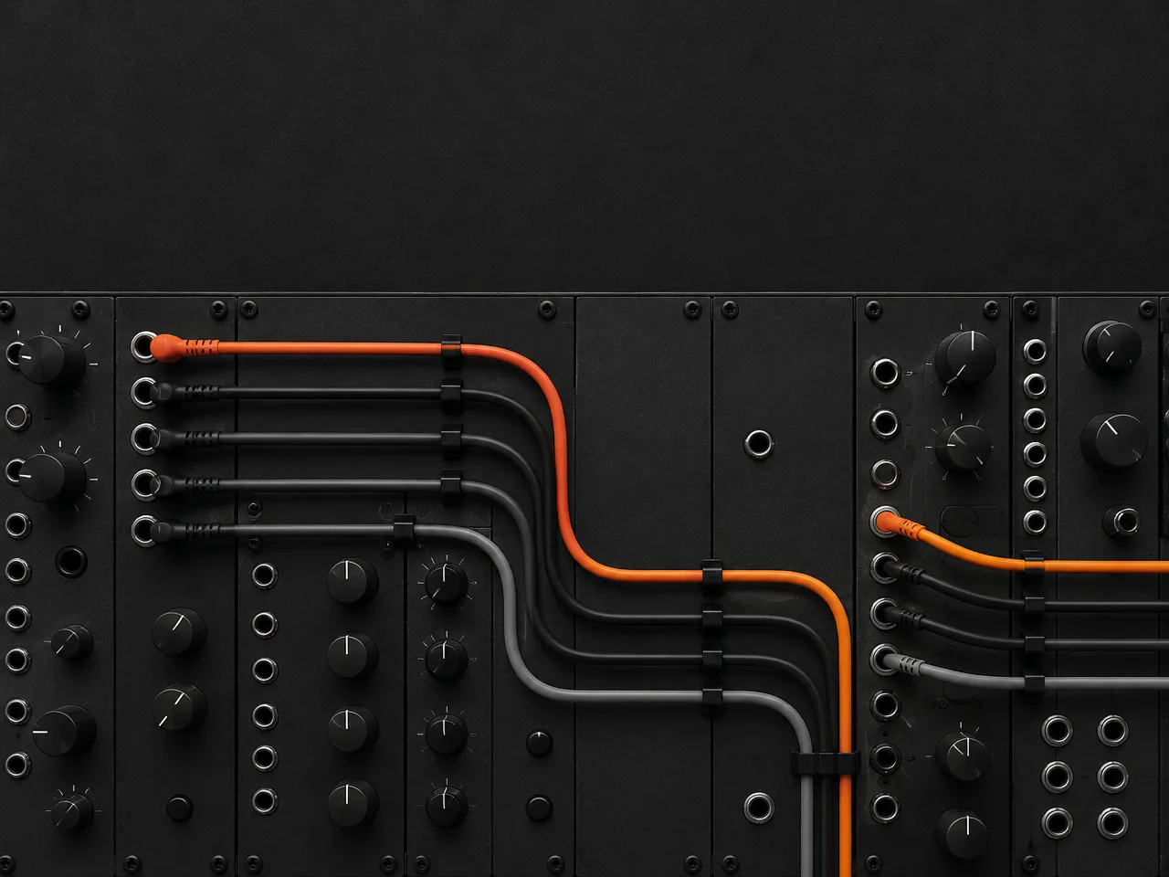 Patch cables routed across a dark synthesizer panel